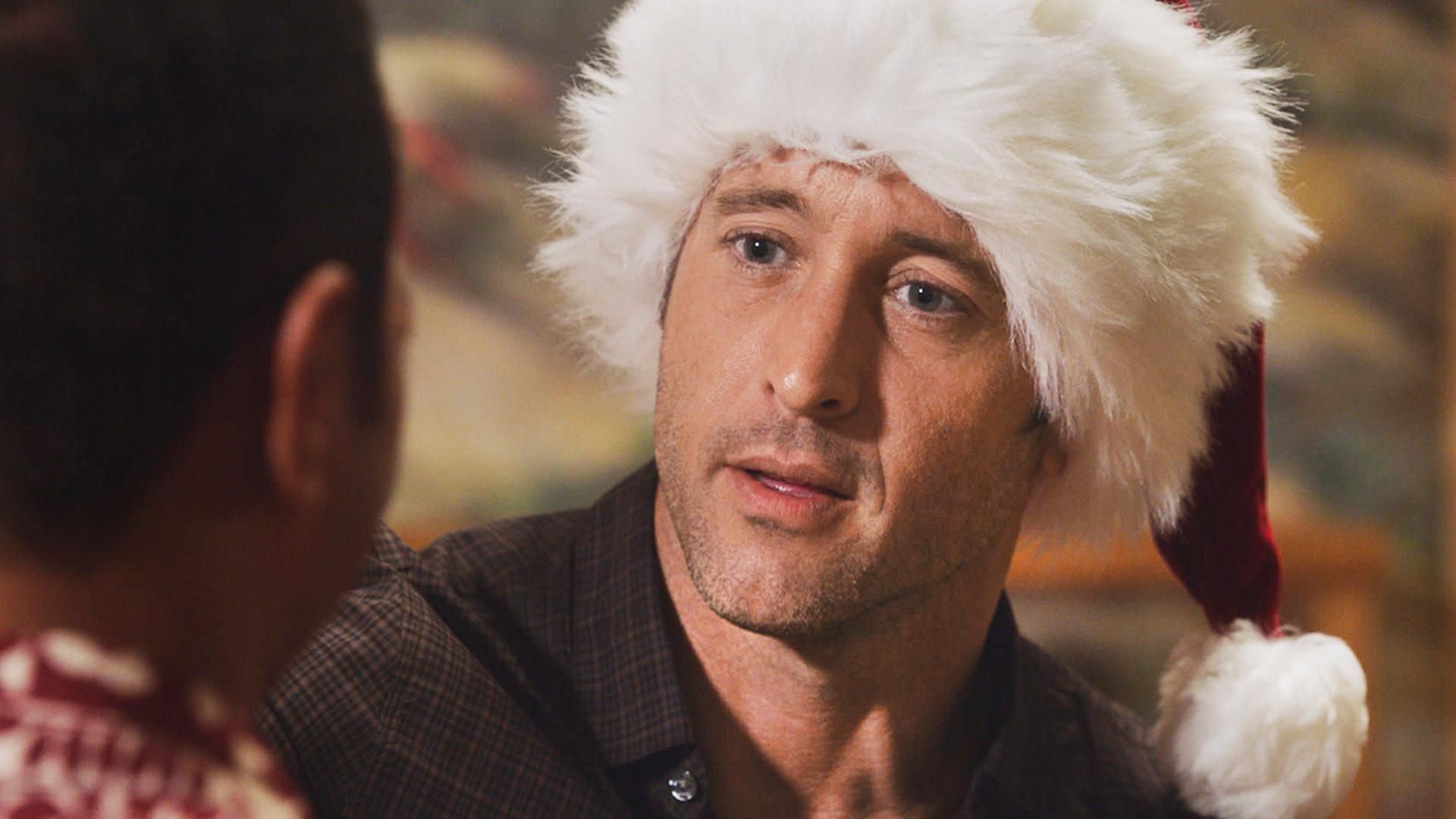 Actor Alex O'Loughlin wearing a substantially furry Santa Claus cap.