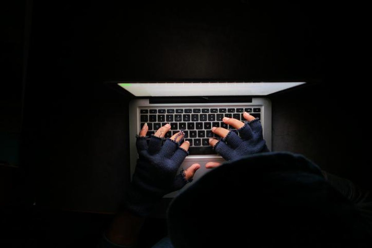 A pair of hands in gloves on a keyboard