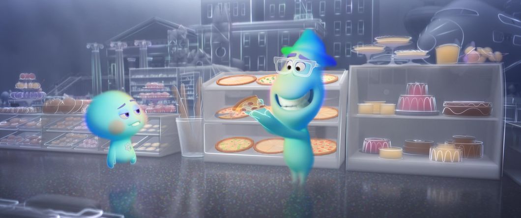 22 and Joe Gardner are standing in the great before. Joe has a pizza slice in hand, bears a large grin and looks humanoid though blobby and colored in shades of blue and green. 22 has child-like qualities to her appearance. In the background, it looks like they're in a cafe, animated in a whimsical, whispy and faint-line style.