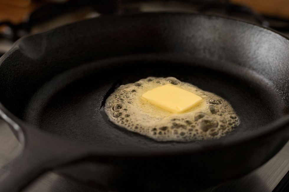 A cast-iron skillet with a dab of butter in the center.
