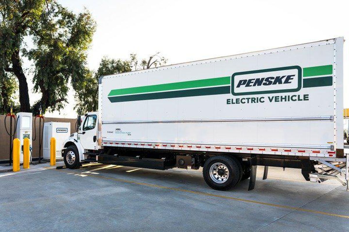 Penske Electric Vehicle in front of charging station