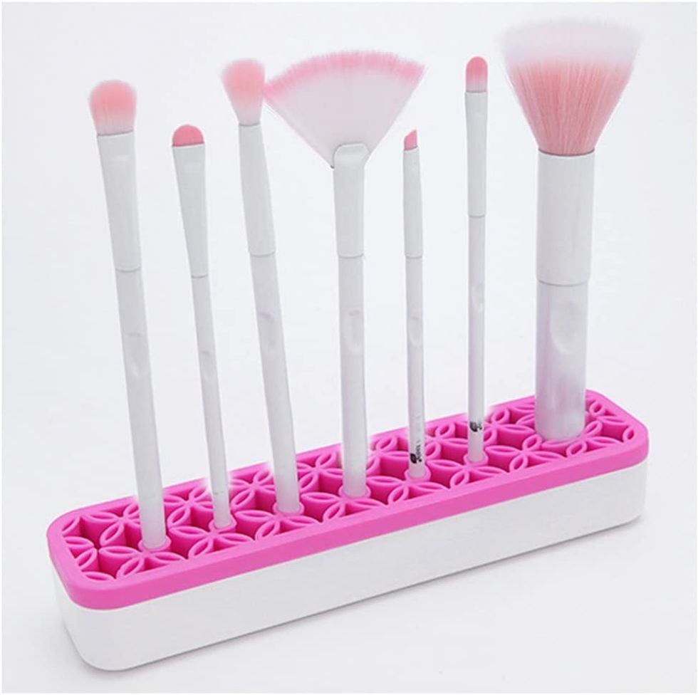 A makeup brush holder holds various brushes.