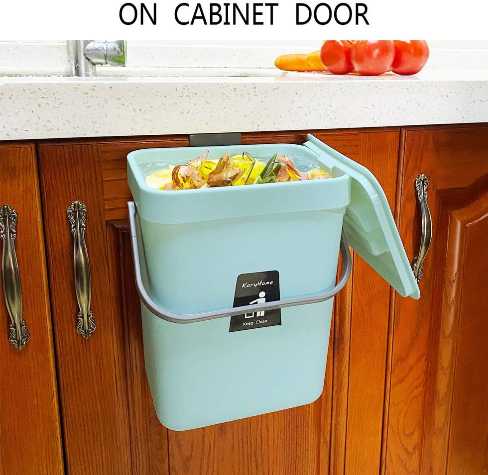 A scrap bin is on the side of a cabinet.