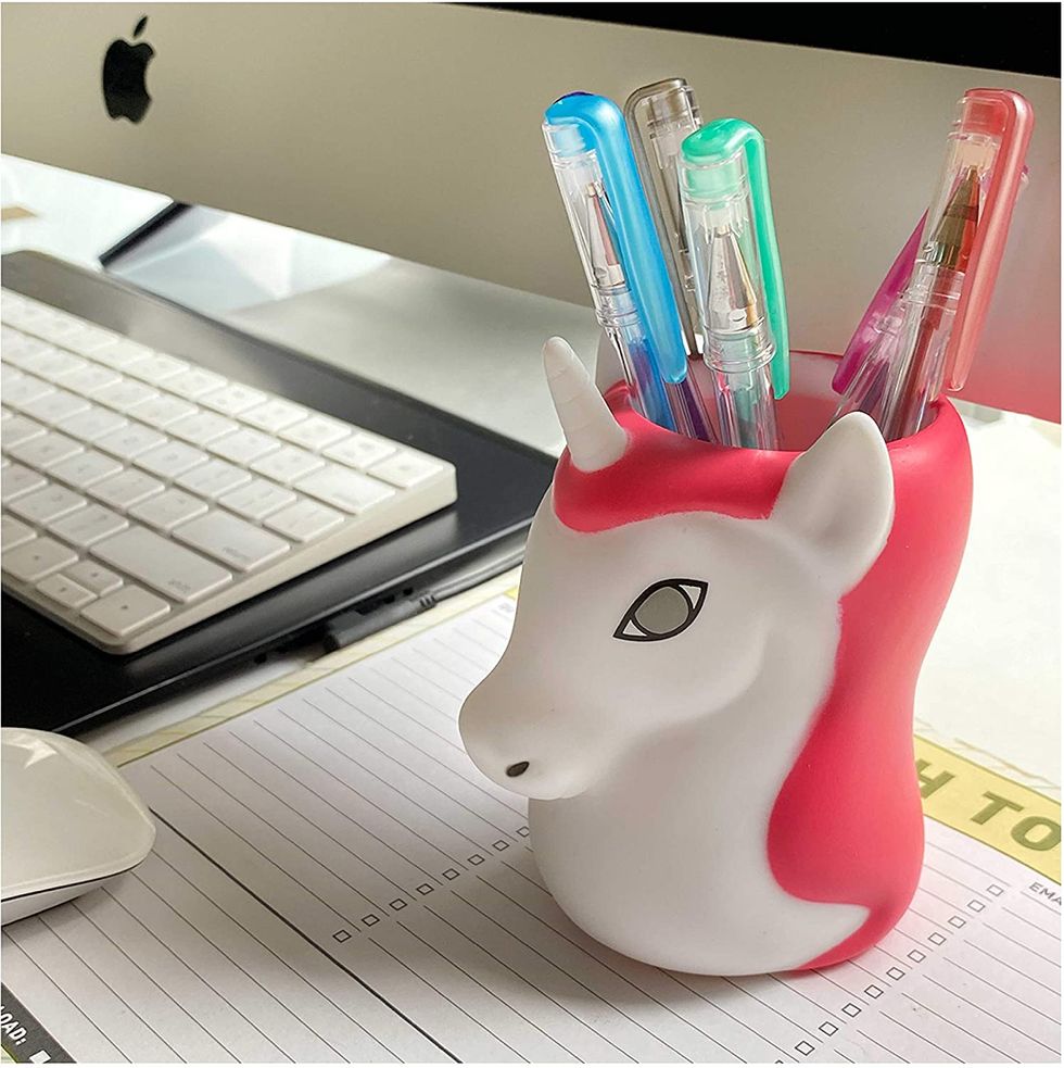 A unicorn cup full of pens.