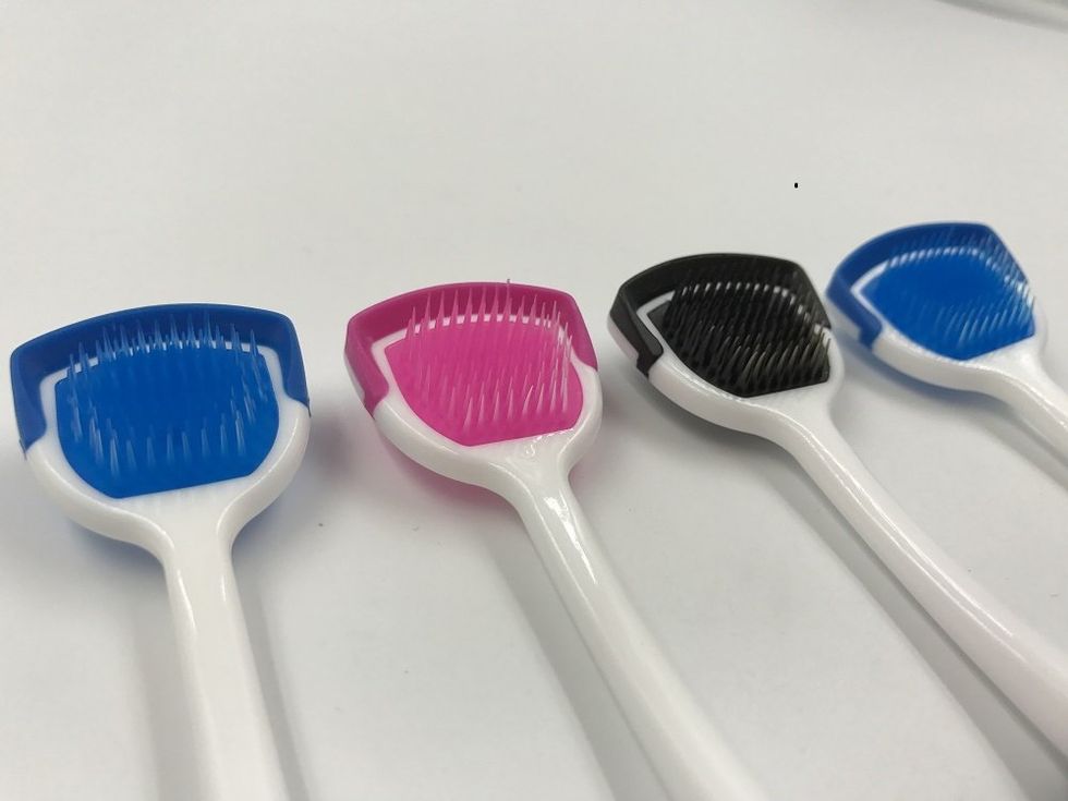 Four tongue scrapers next to each other.