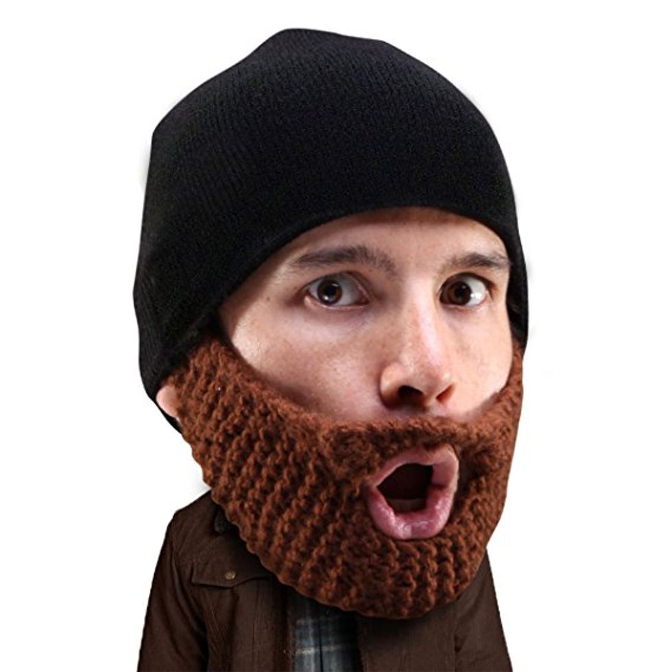A man wears a beanie that has a fake beard attached.