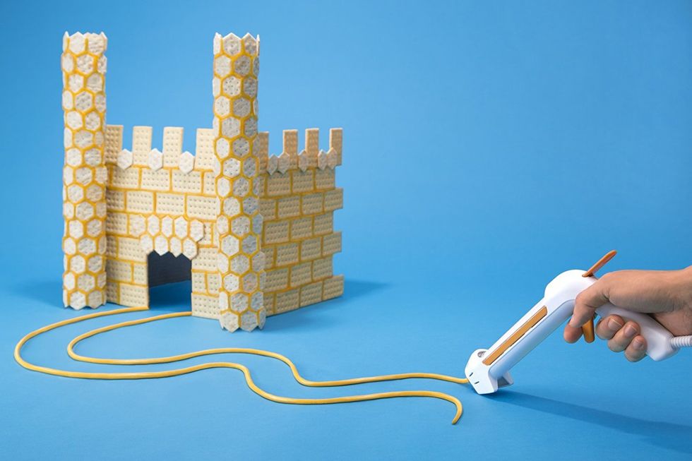 A hot glue gun that uses cheese builds a castle.
