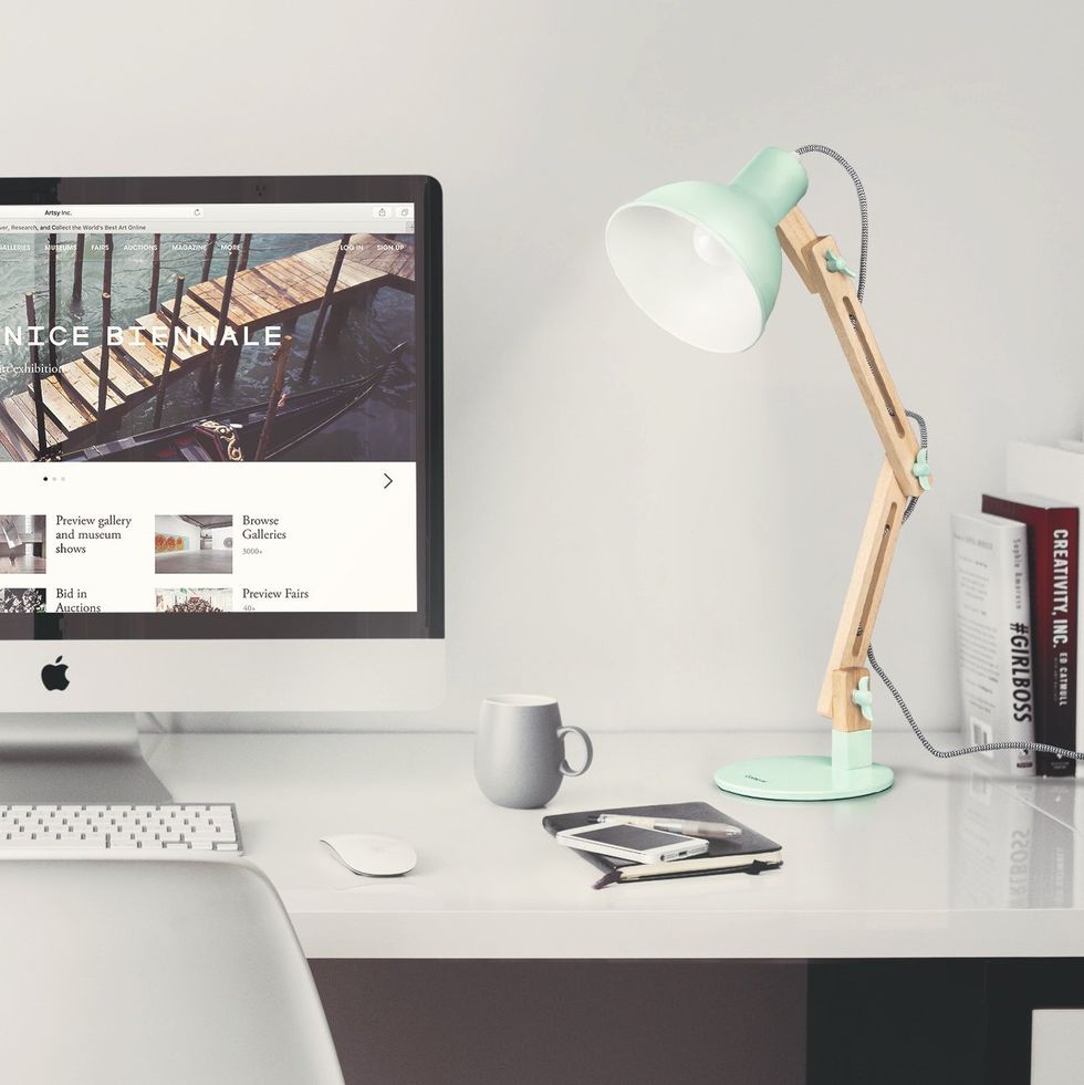 A white desk full of modern office items.