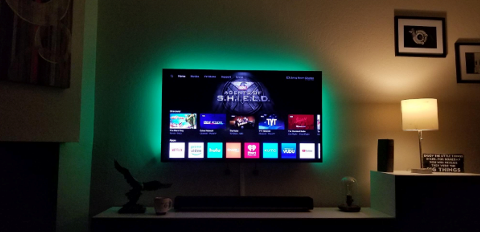 A green LED light strip behind a TV.