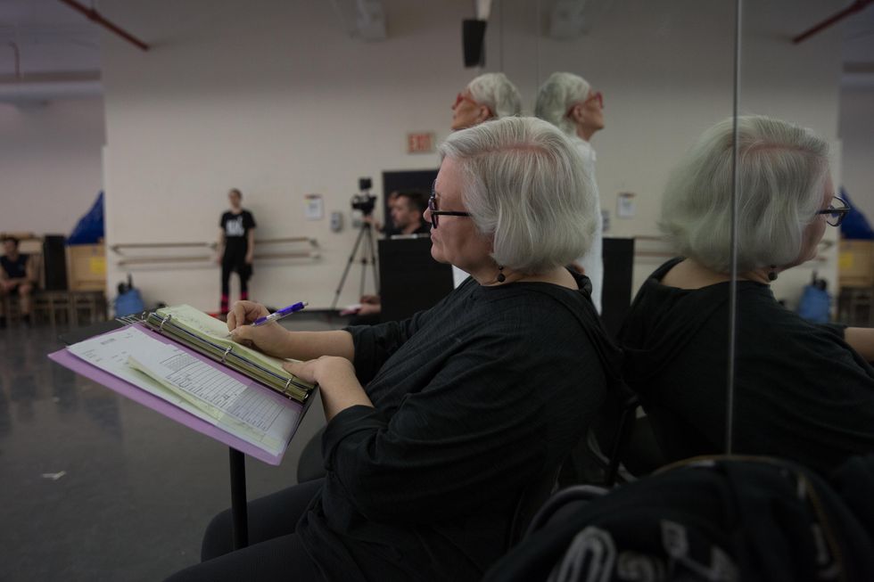 Jones sits at the front of the studio writing on paper in a binder propped up on a music stand. Practice 10 to 20 repetitions or until muscles start to fatigue, using a medium-strength band.• Sit on the floor with the legs out in front of you, keeping a straight spine. data-prebid=