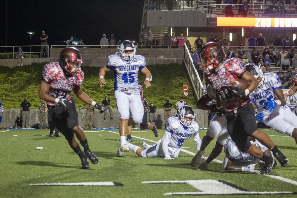 Josh Evans-Pickens, #10 runs with the all. As his brother Caleb Evans-Pickens, #34 gets ready to make a tackle to protect his younger brother.