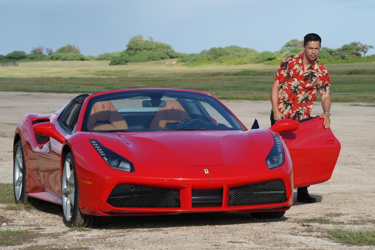 Magnum getting out of his red Ferrari wearing a red Hawaiian shirt