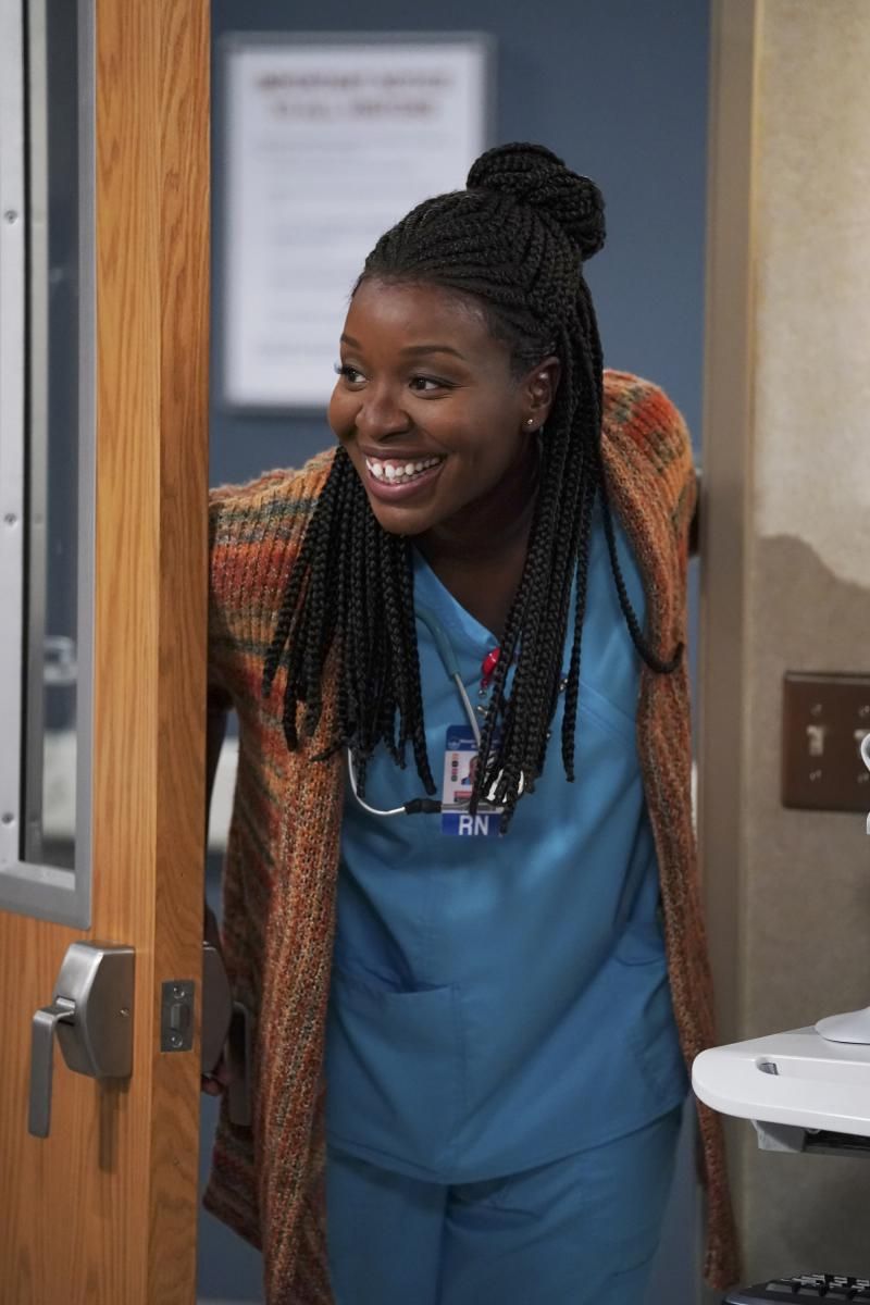 Abishola smiling as she enters a hospital room