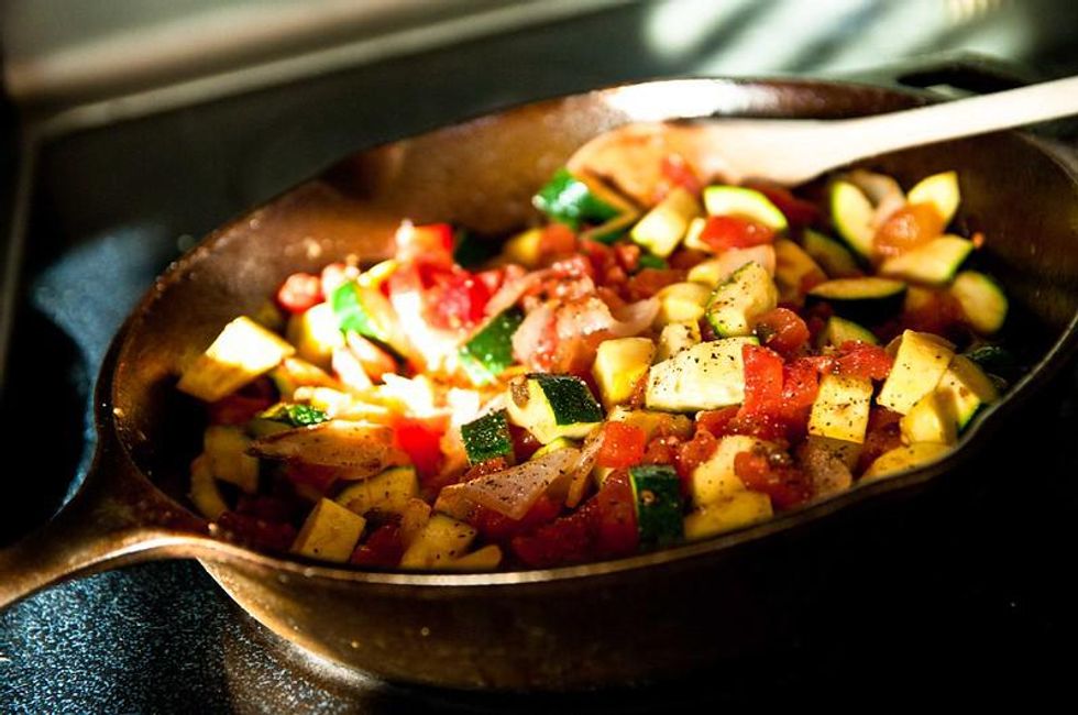 cast iron pan with sautu00e9ed vegetables