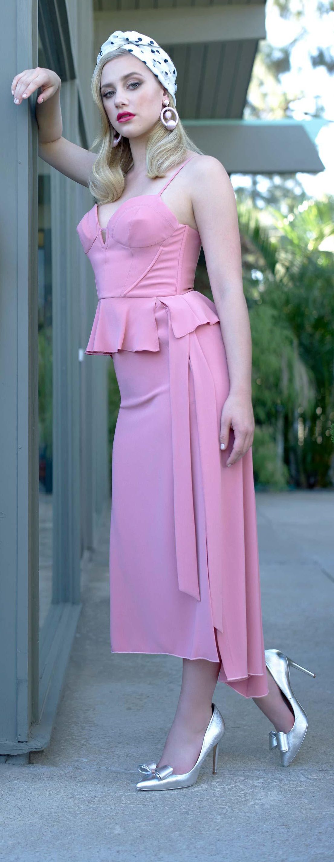 Lili Reinhart looks retro chic in a polka dot turban paired with a pink bustier and matching skirt