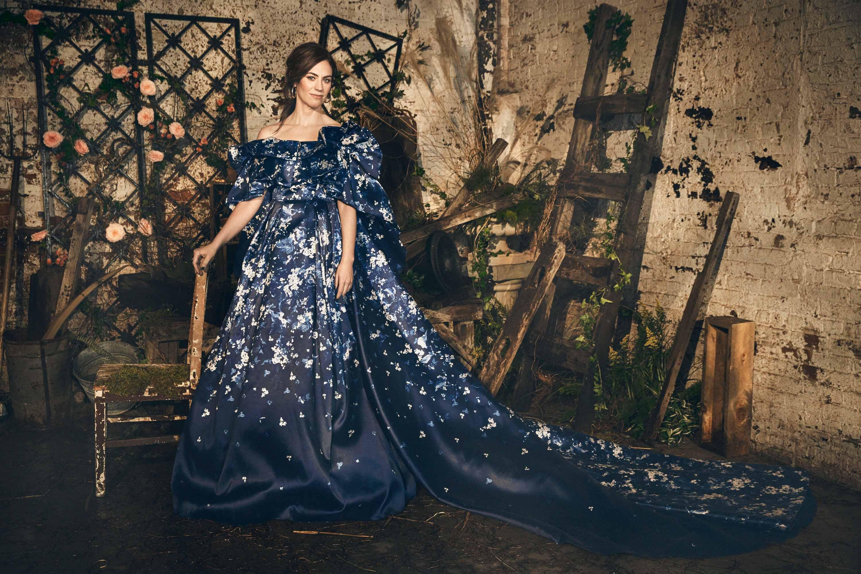Maggie Siff in a dark blue floral gown with a flowing train