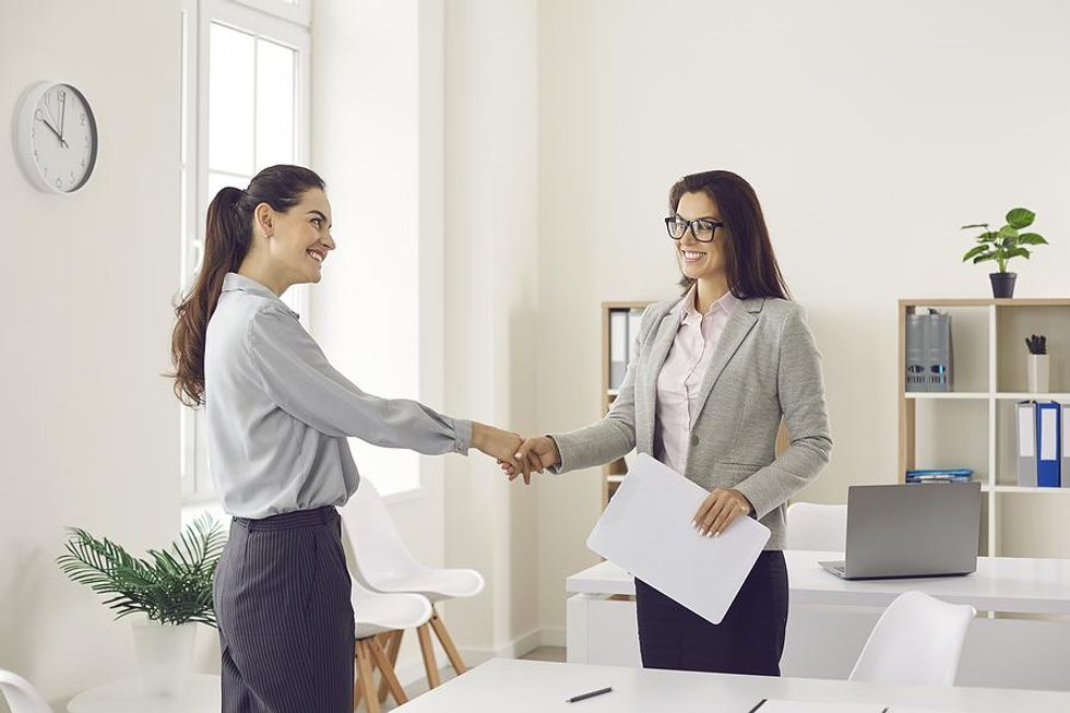 Woman shakes the hiring manager's hand before her job interview
