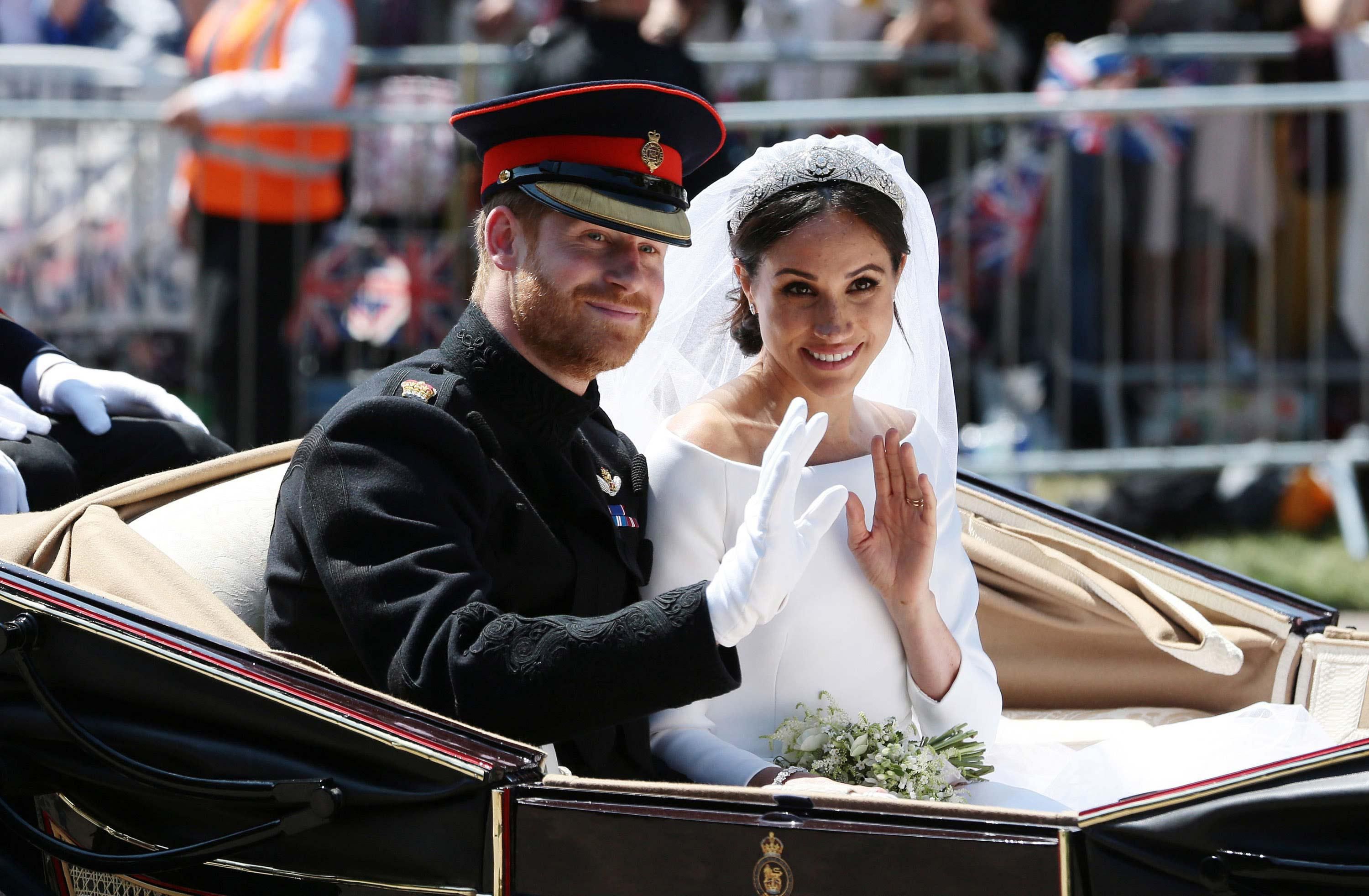 \u200bHarry and Meghan pose for a photo in an open-top carriage at their wedding