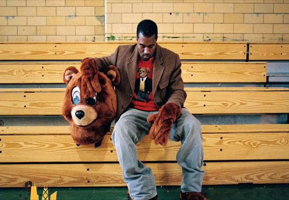 Kanye West in a bear custom sitting on bleachers