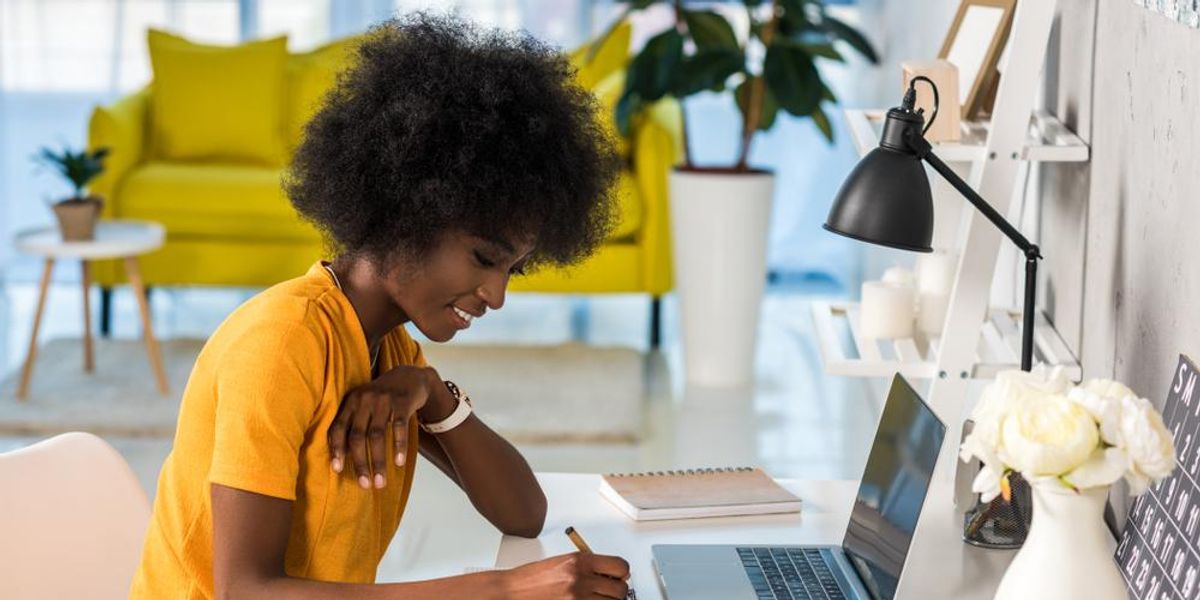 African-American woman in a yellow shirt and afro at work