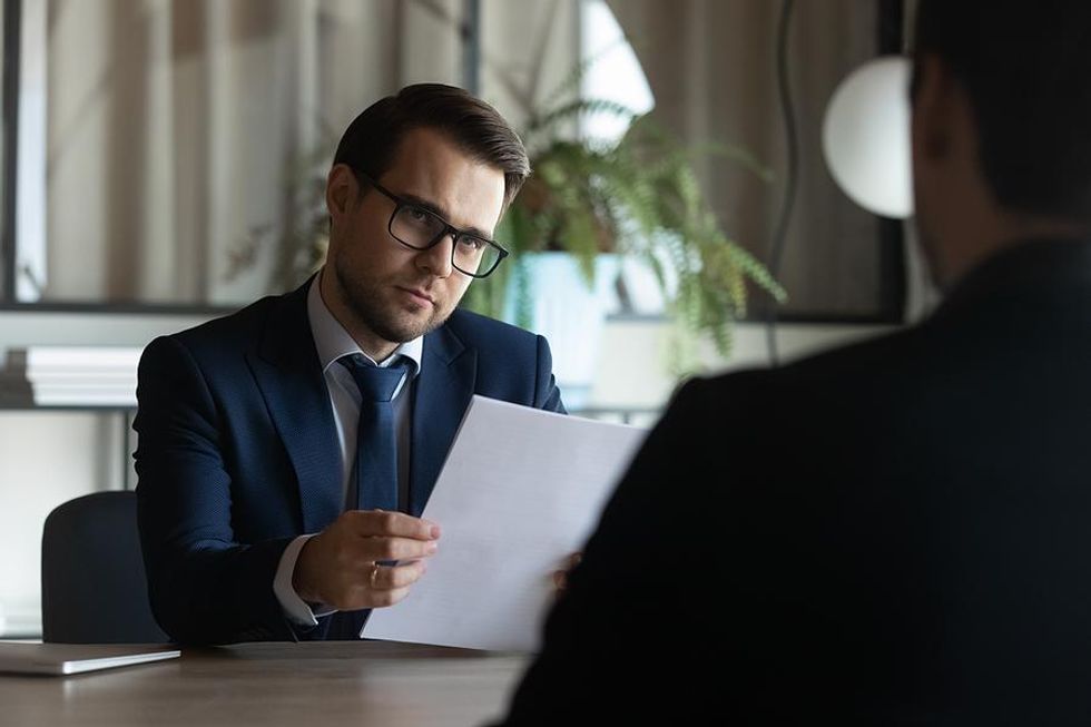 Hiring manager looks at job candidate after he ask a desperate question
