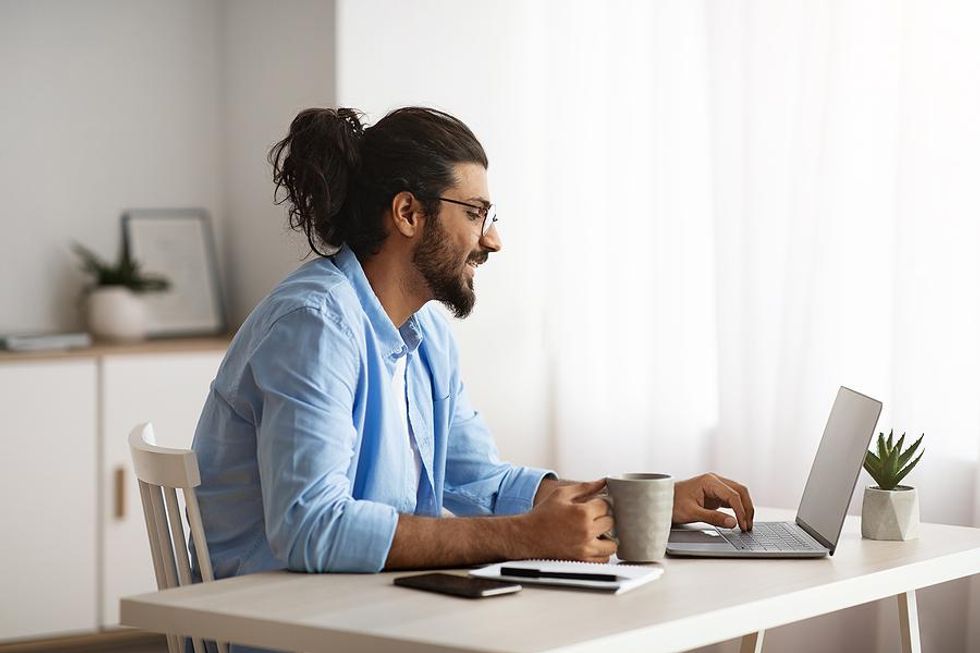 Man drinks coffee while working from home