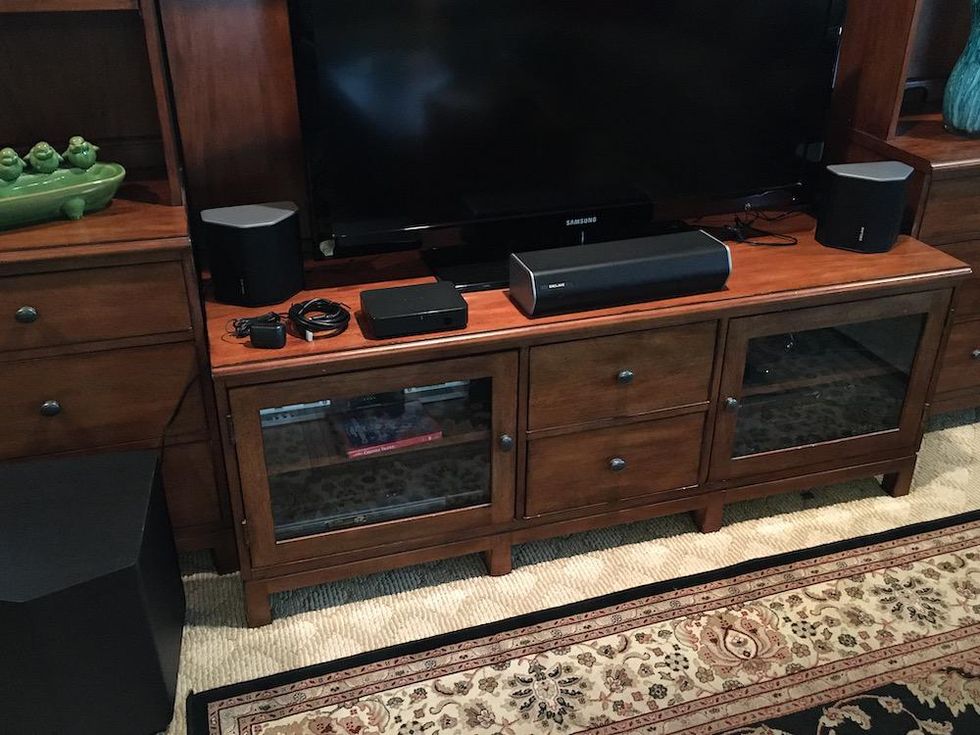 Photo of Enclave Audio CineHome II Wireless Home Theatre system unboxed infront of a TV