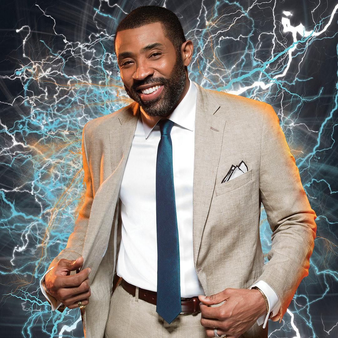 ​Cress Williams in a suit and tie against a lightning backdrop