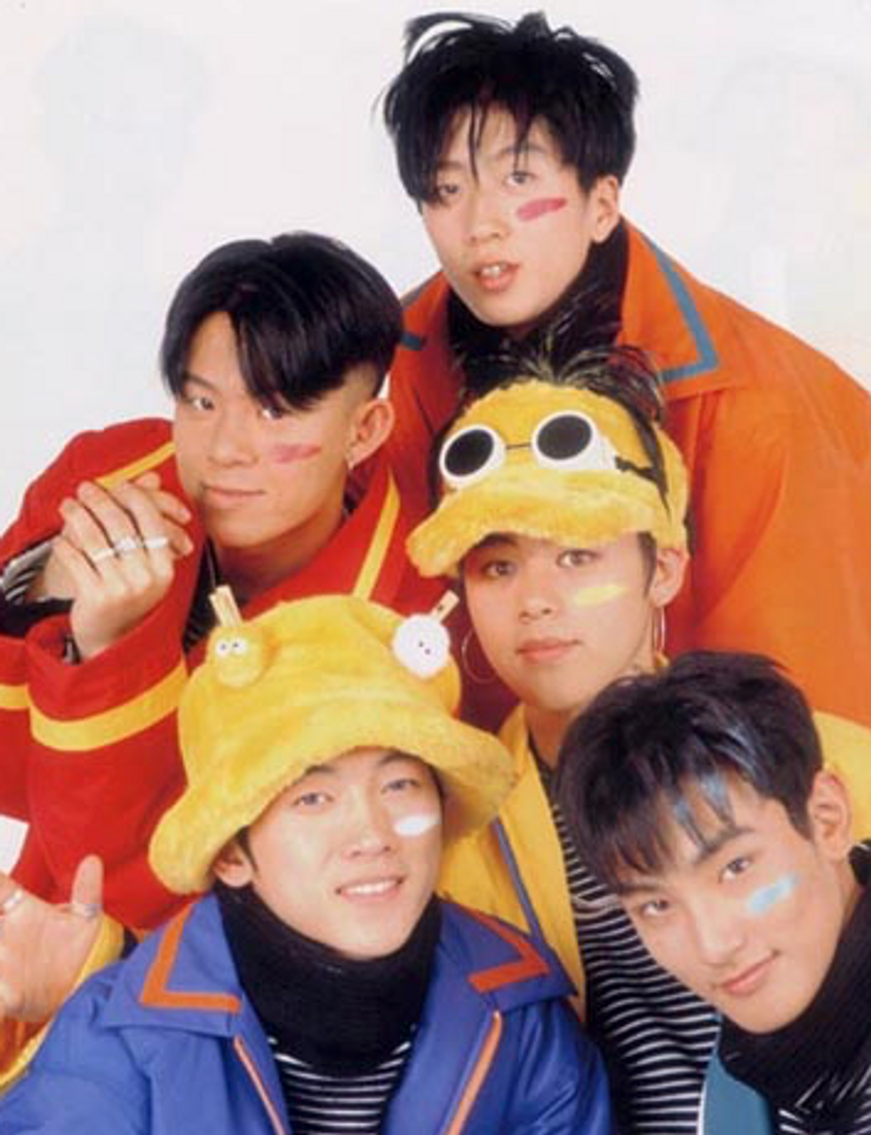 Young Korean teens wearing bright clothes, fuzzy hats, and pastel marks under their eyes kind of like American football players
