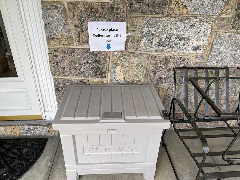 Sign on wall to instruct delivery services to place package inside box.