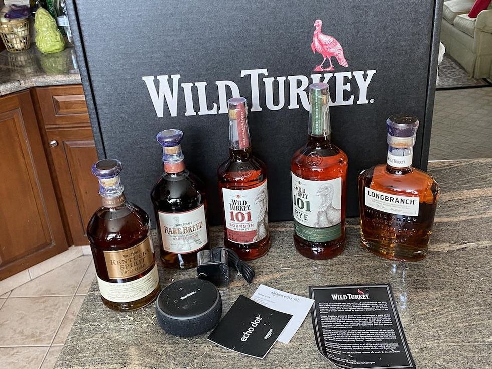 a photo of 5 bottles of Wild Turkey and echo dot on a countertop