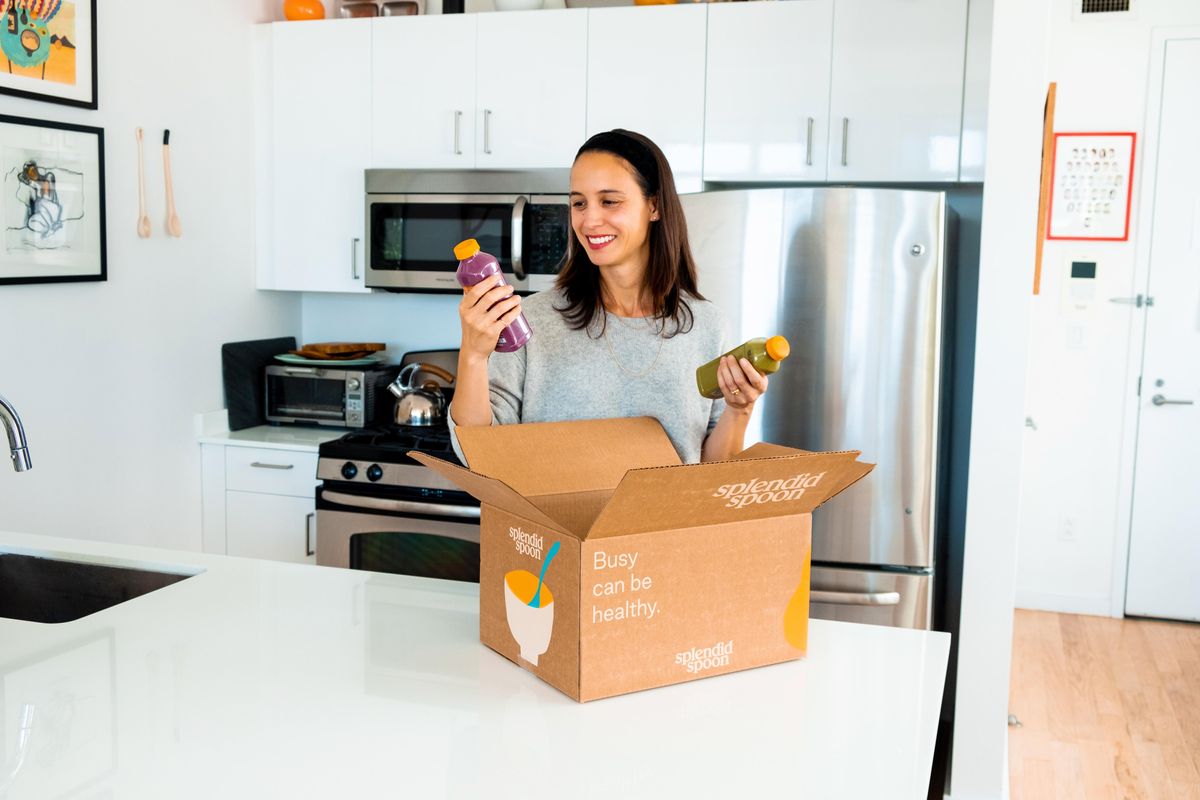 woman unpacking her splendid spoon delivery in her kitchen 