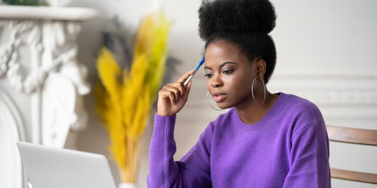 black-woman-thinking-pen-laptop