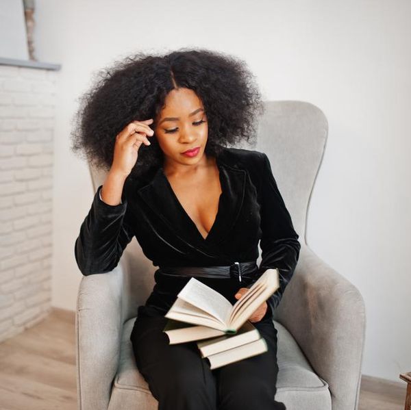 stylish-black-woman-reading-fireplace
