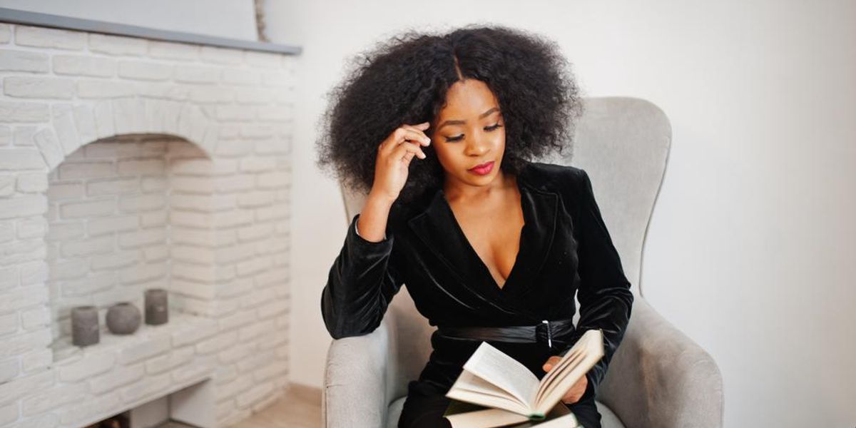 stylish-black-woman-reading-fireplace