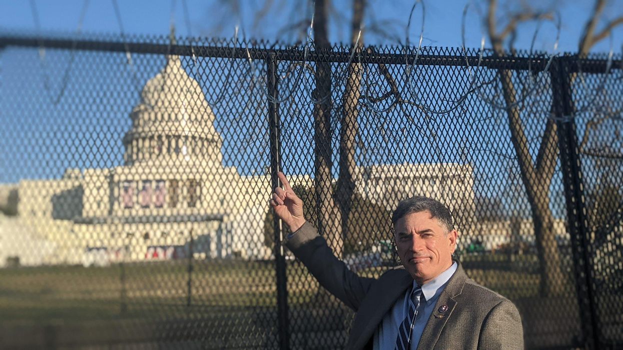 Rep. Andrew Clyde pointing at security fencing around the Capitol. 