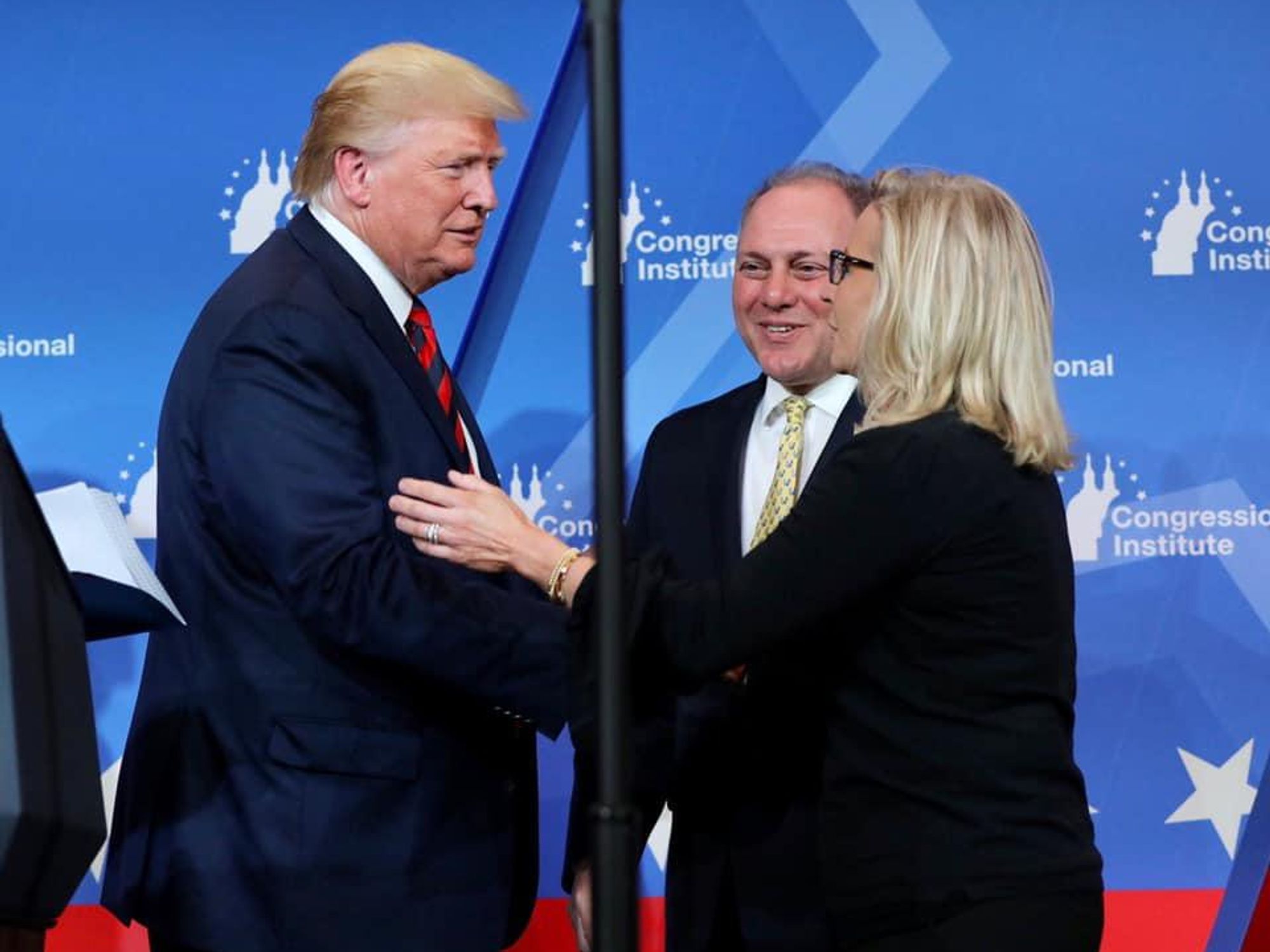 Rep. Liz Cheney, right, shaking hands with former President Trump.