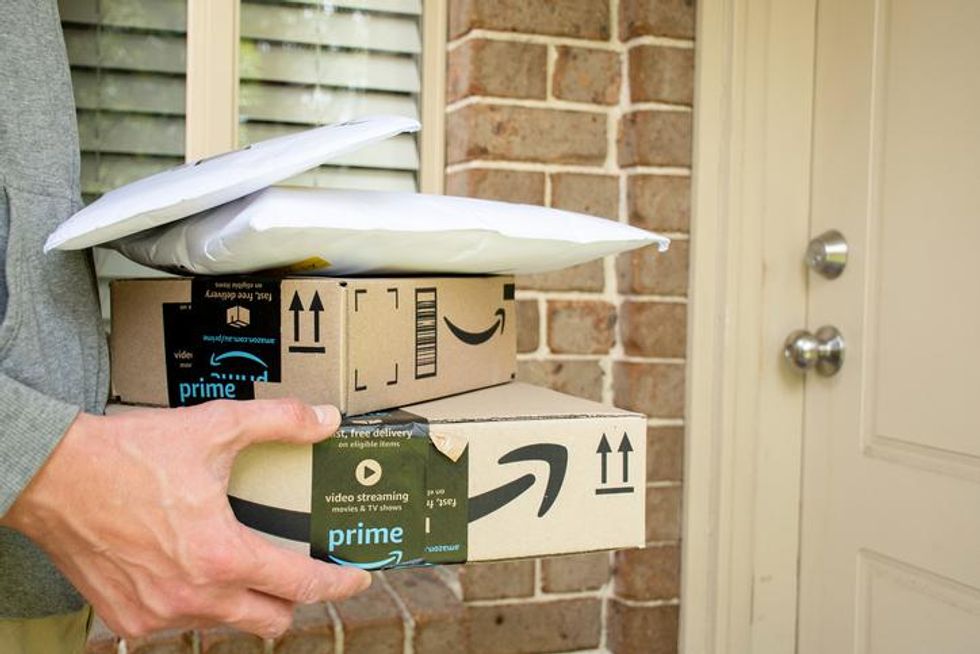Hands holding Amazon Prime shipping boxes