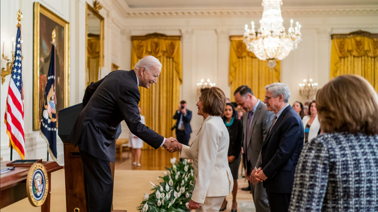 President Biden, left, greets House Speaker Pelosi after signing the Covid-19 Hate Crimes Act