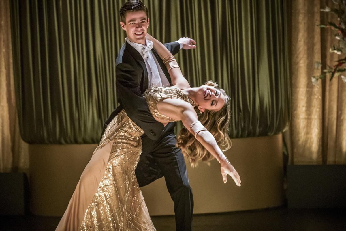 Grant Gustin as Barry Allen and Melissa Benoist as Kara singing and dancing