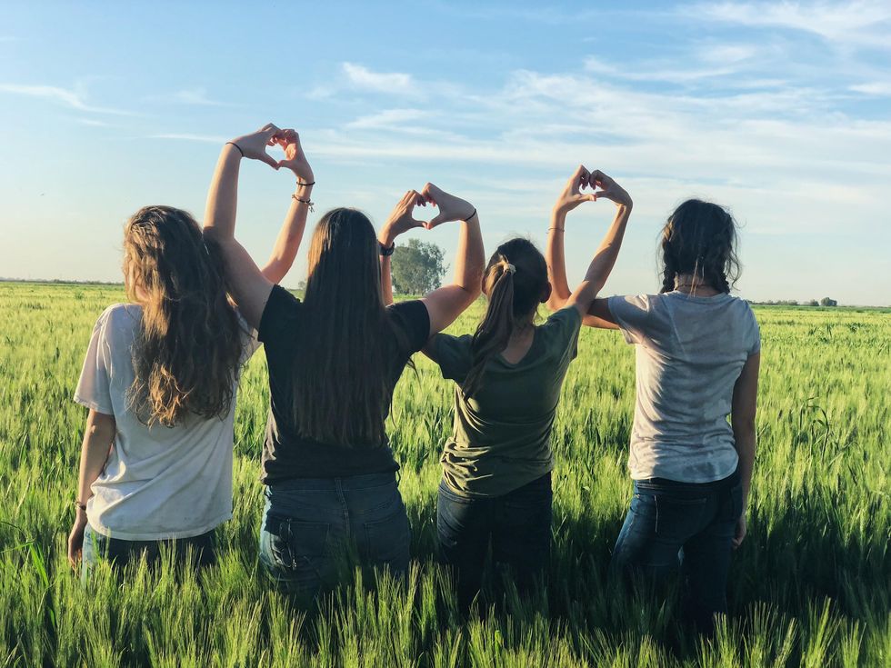 Photo of girls forming hearts with their hands