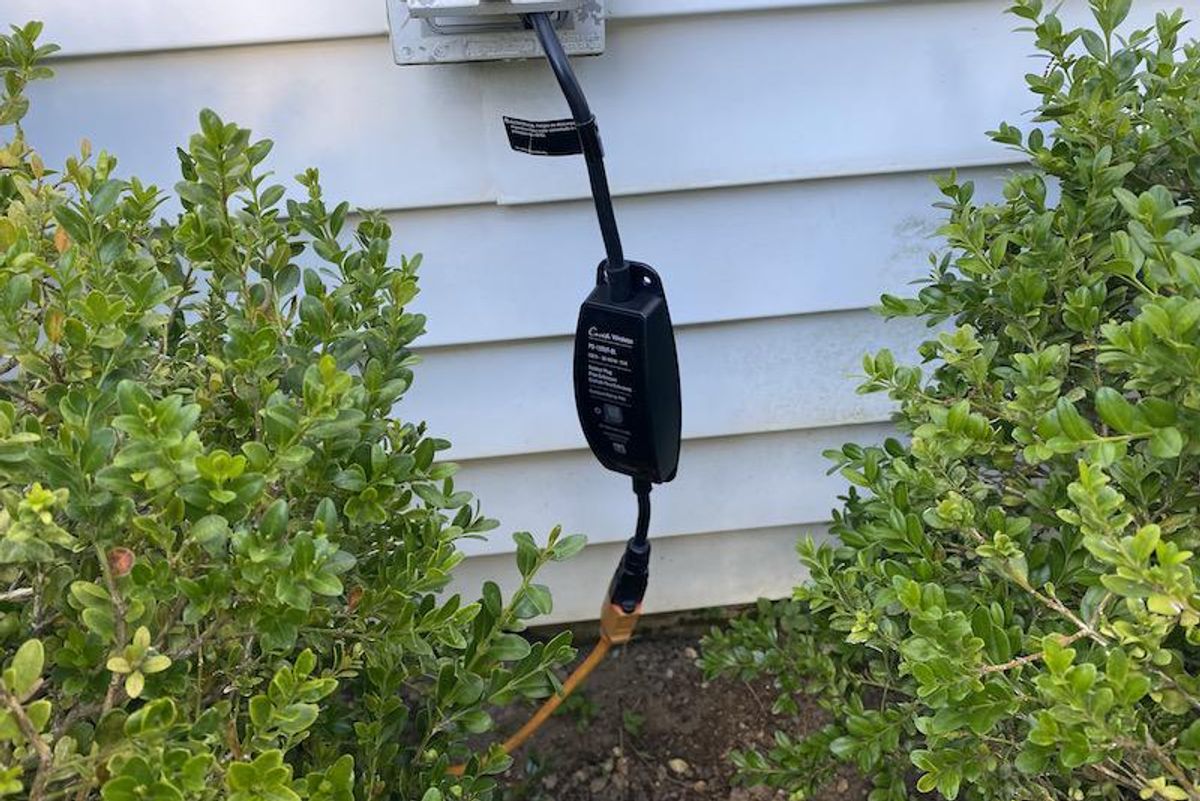 Lutron Caseta Outdoor Smart Plug plugged in an outdoor outlet.