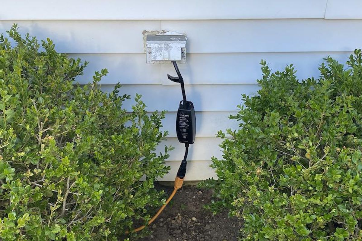 Lutron Outdoor Smart Plug plugged in an outlet outside a home.