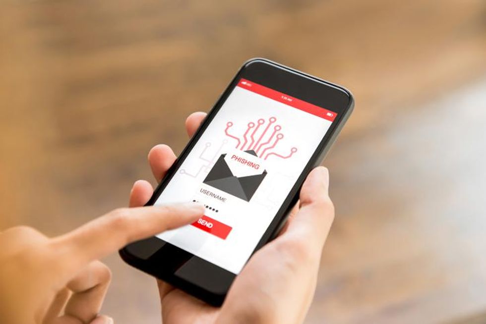 Someone clicking on a phishing email on their mobile phone