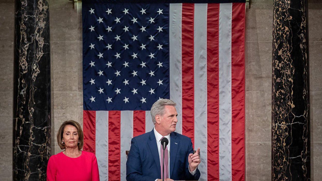 House Minority Leader Kevin McCarthy, center, speaks with Speaker Nancy Pelosi behind him.