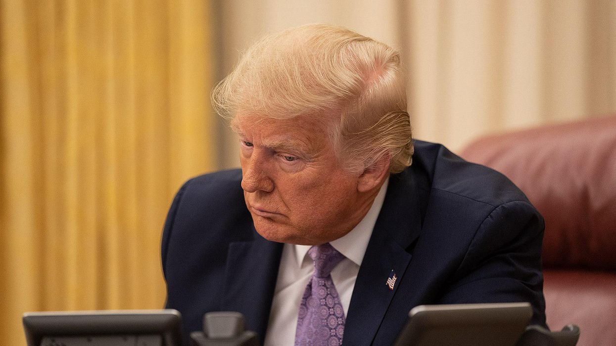 Former President Trump takes a phone call in the Oval Office.