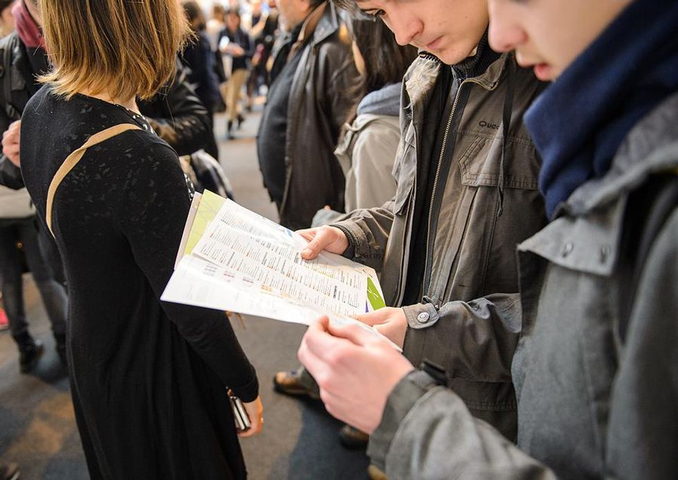 Two men look at the companies attending a job fair