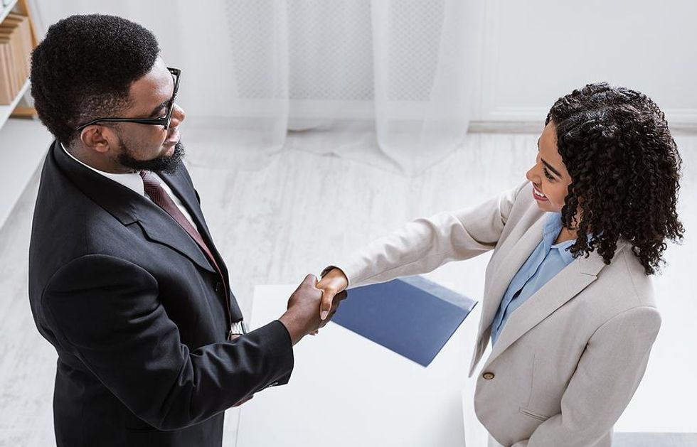 Job seeker shakes hands with an employer at a job fair