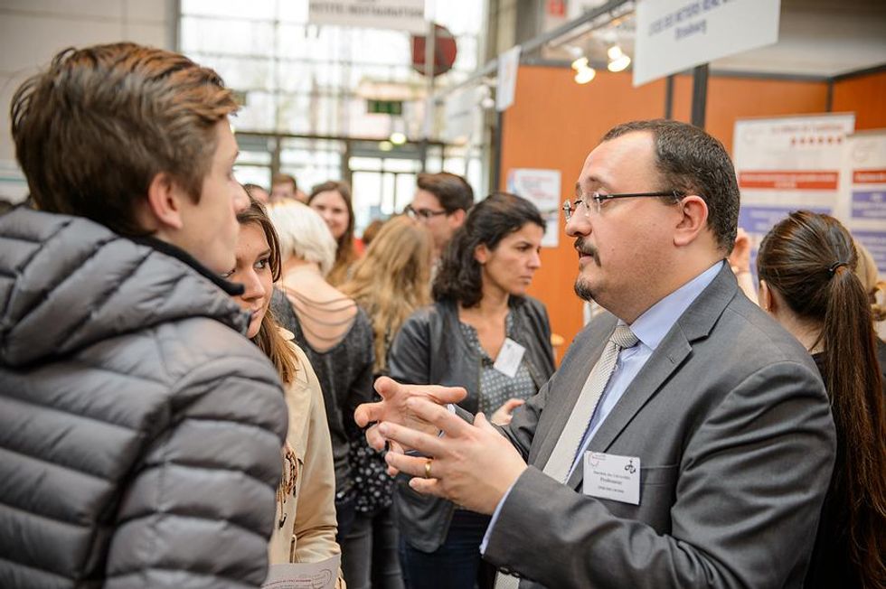 Job seekers talk to an employer at a job fair