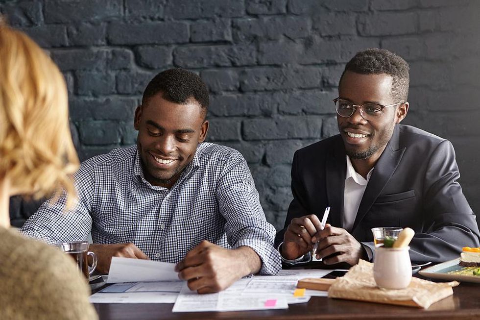 Employers at a job fair talk to a job seeker